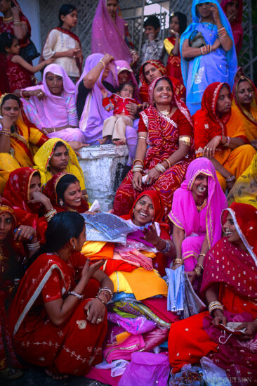 An Indian Bride surrounded by other women, both family and friends, as she receives wedding gifts.