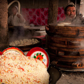Kashgar open market with food vendors preparing pasta and momos.