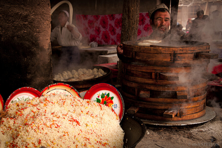 Kashgar open market with food vendors preparing pasta and momos.