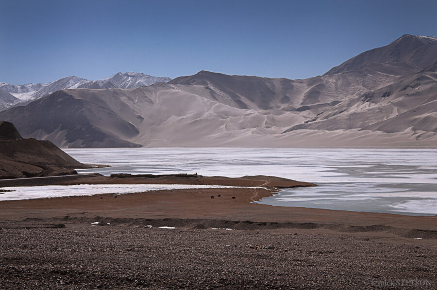 Landscape of a lake at the foot of the Sand Mountains in the Kashgar Oasis.