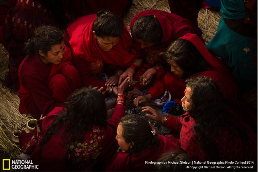 Hindu women in a circle completing the morning rituals for Swasthani Festival in Nepal.