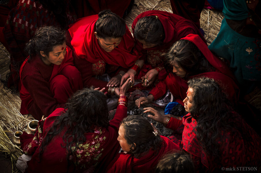 Hindu women in a circle completing the morning rituals for Swasthani Festival in Nepal.